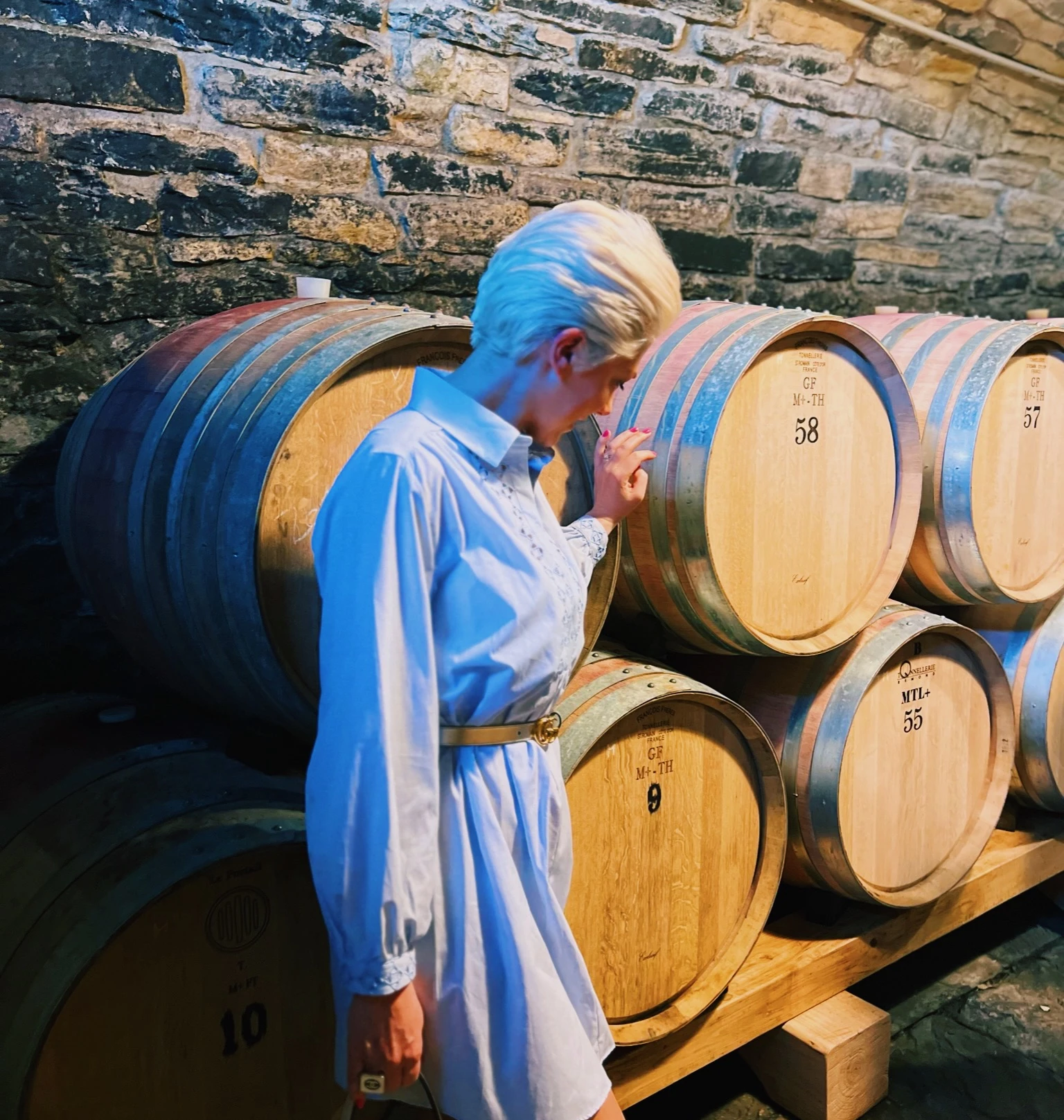 Elizabeth examines wine barrels in Savignola’s stone-walled cellar.