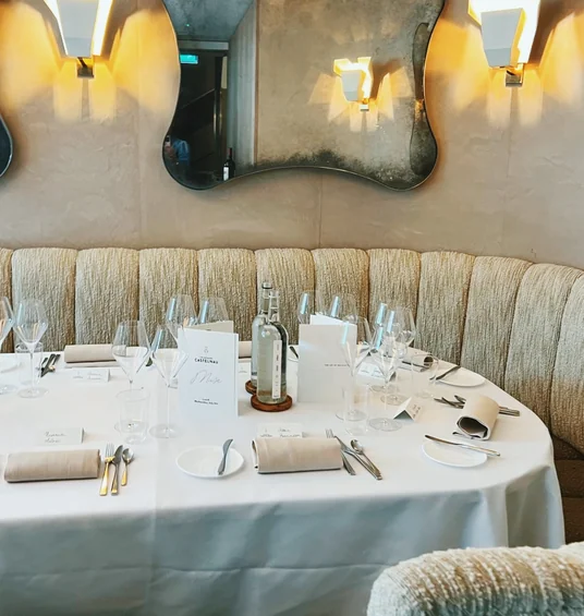 Elegant restaurant table set with Champagne Castelnau menus, wine glasses and place settings