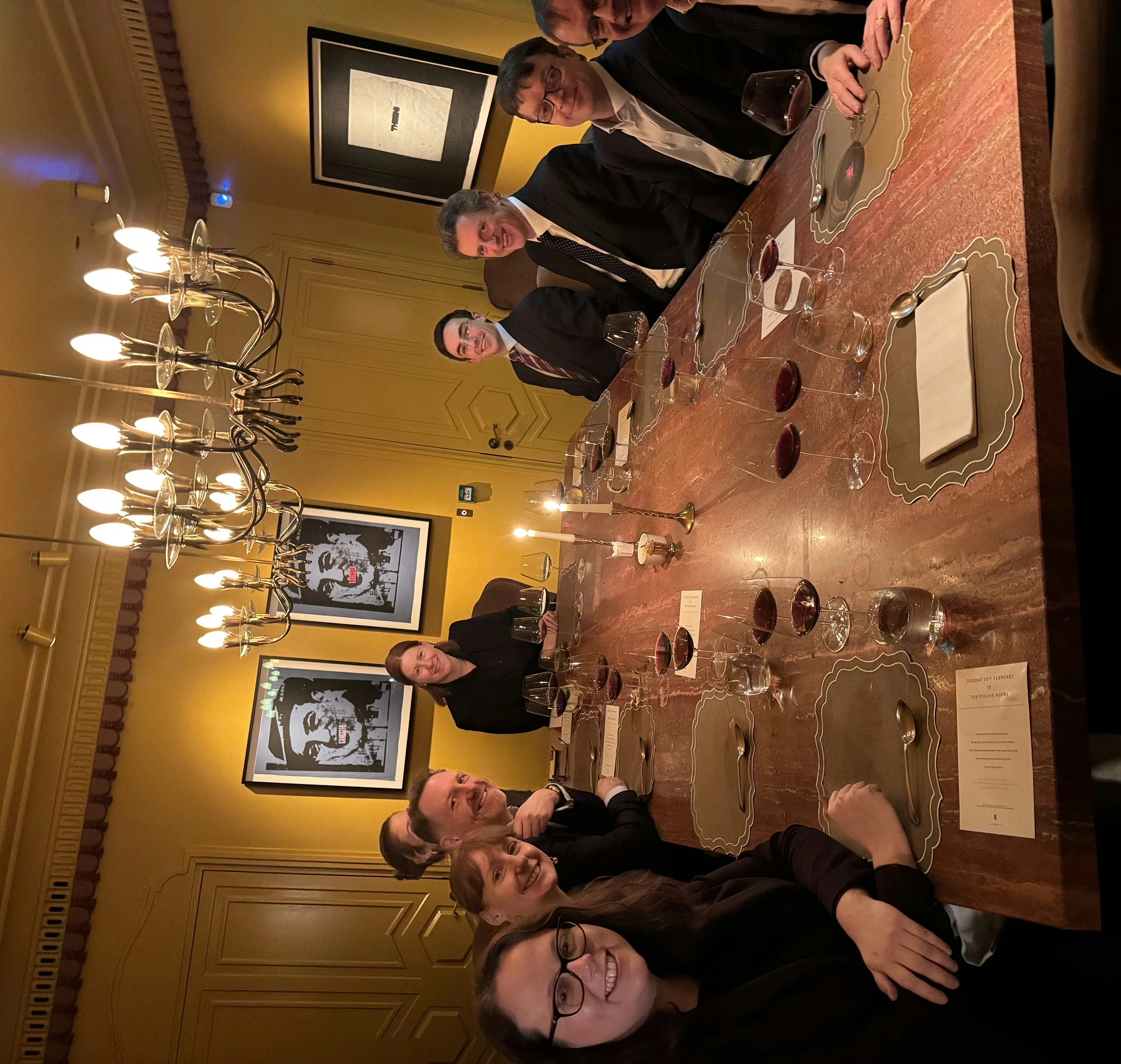 Guests gather around a set table for a corporate wine dinner in an elegant London dining room.