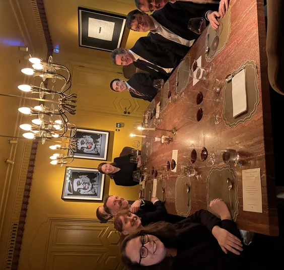 Guests gather around a set table for a corporate wine dinner in an elegant London dining room.