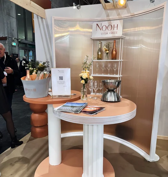Nooh by La Coste wine stand with bottles, glasses, flowers and brochures at Wine Paris