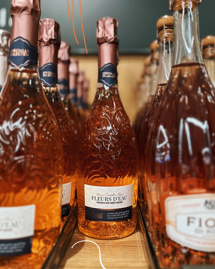 Bottle of Fleurs d’Eau sparkling brut rosé surrounded by other rosé wine bottles