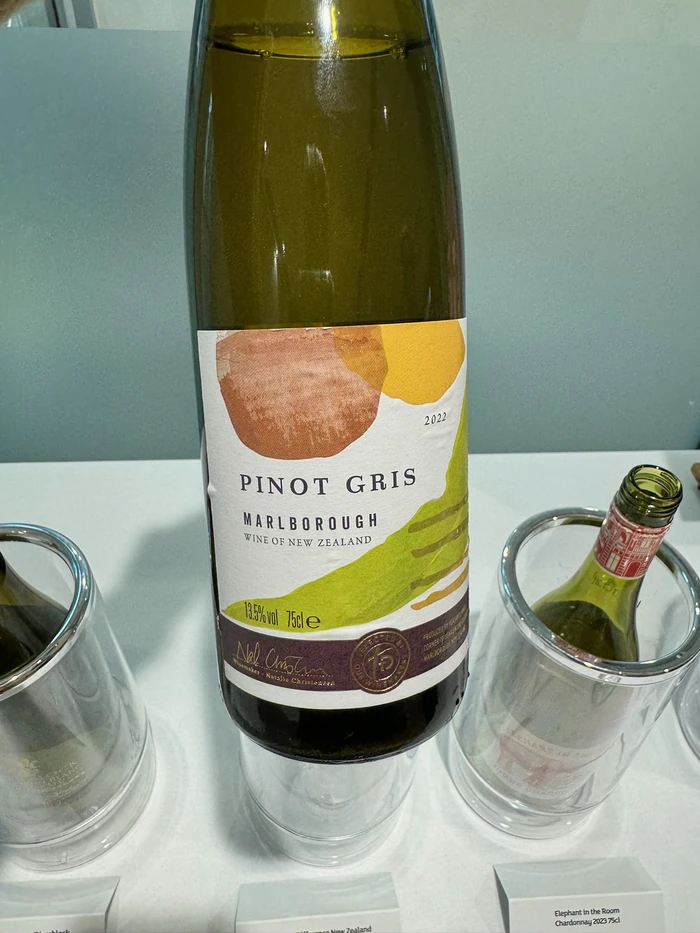 Pinot Gris bottle beside wine glasses and an opened bottle at a tasting table