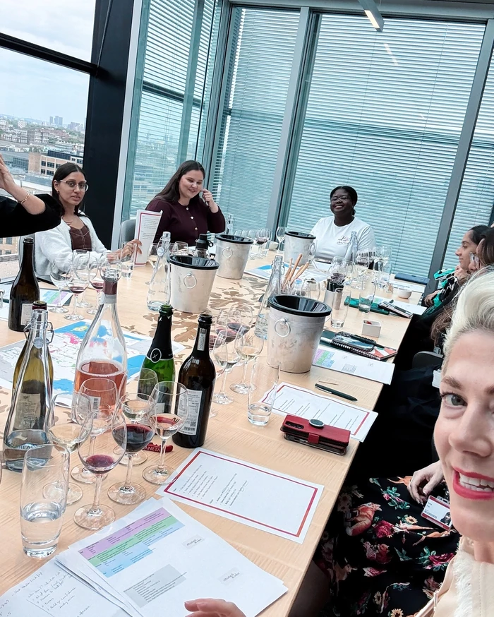 Corporate wine tasting around a table with wine glasses, bottles and tasting notes