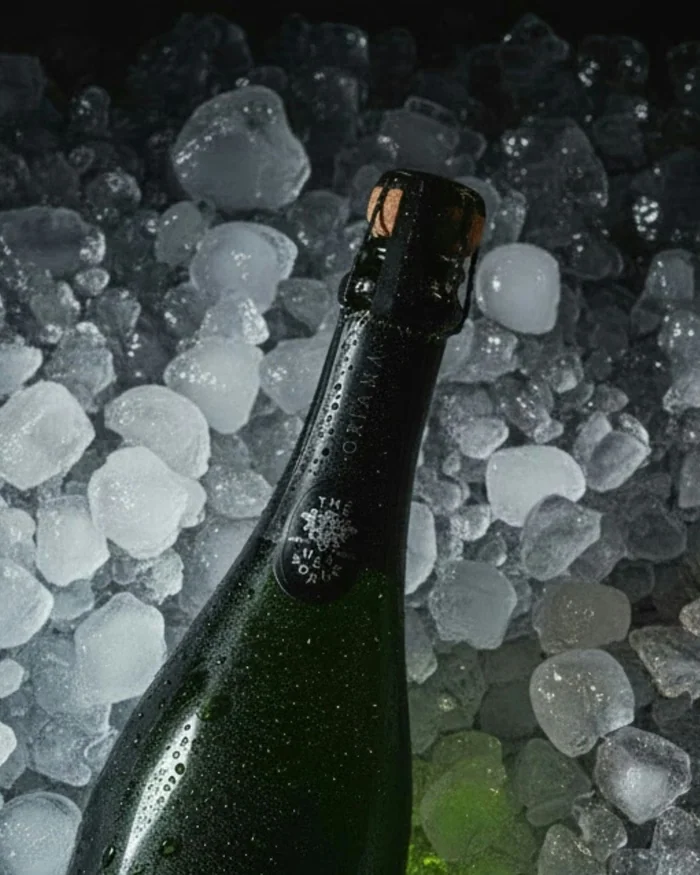 Close-up of a sparkling wine bottle resting in crushed ice