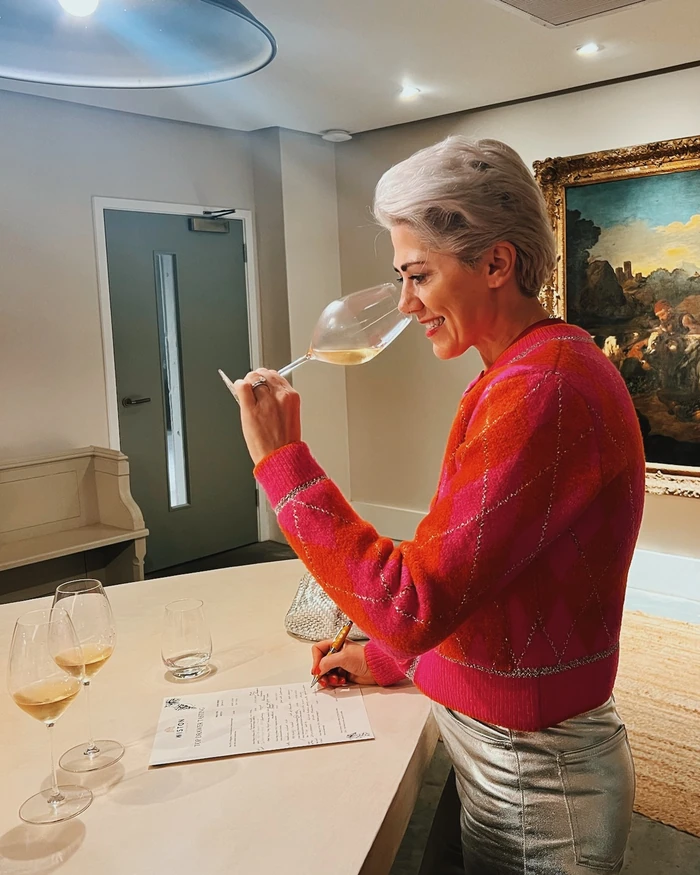 Woman tasting English wine and writing notes at a Wiston tasting table