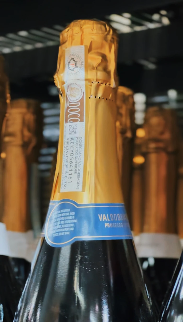 Close-up of a Valdobbiadene Prosecco bottle with gold foil and blue label