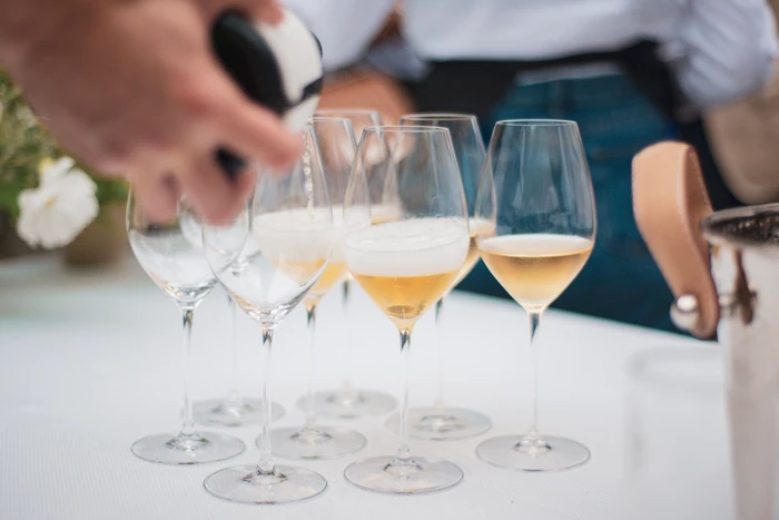 Glasses of sparkling wine being poured at a tasting table