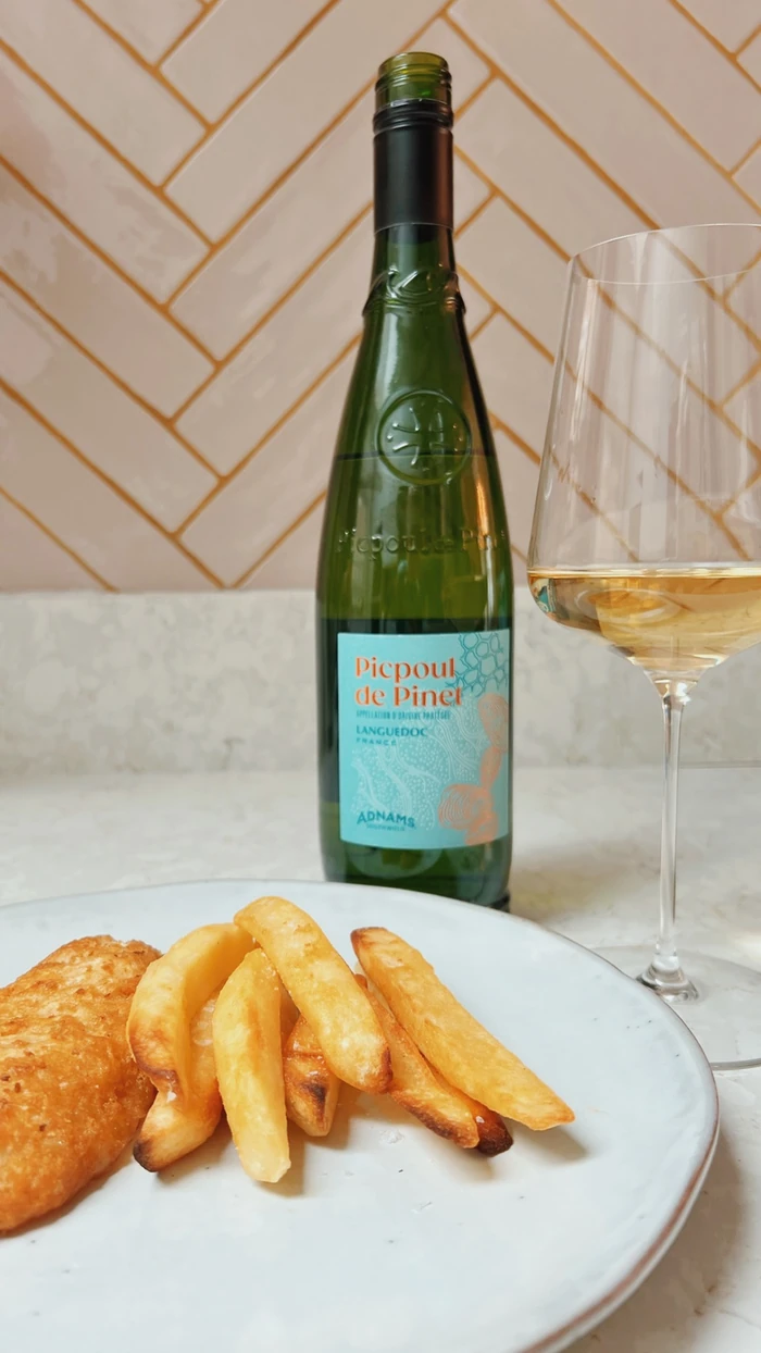 Picpoul de Pinet beside a glass of white wine and fish and chips