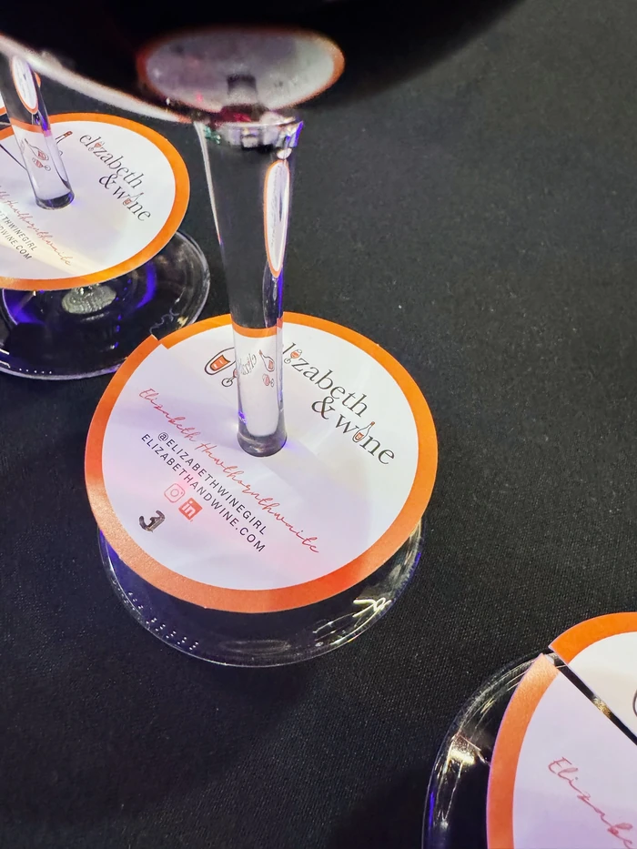 Wine glasses with Elizabeth & Wine tasting cards on a dark table