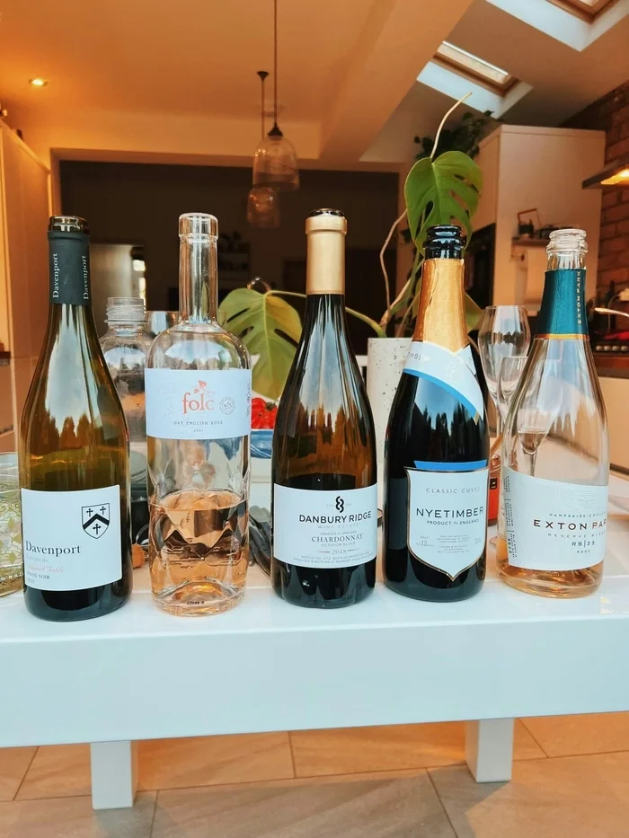Five English wine bottles displayed on a table, including Davenport, Folc, Danbury Ridge, Nyetimber and Exton Park