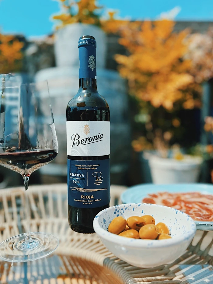 Beronia Reserva 2018 Rioja wine bottle beside a glass of red wine and bowls of appetisers