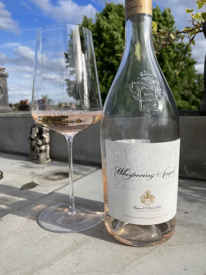 Whispering Angel rosé beside a glass of wine in bright sunshine