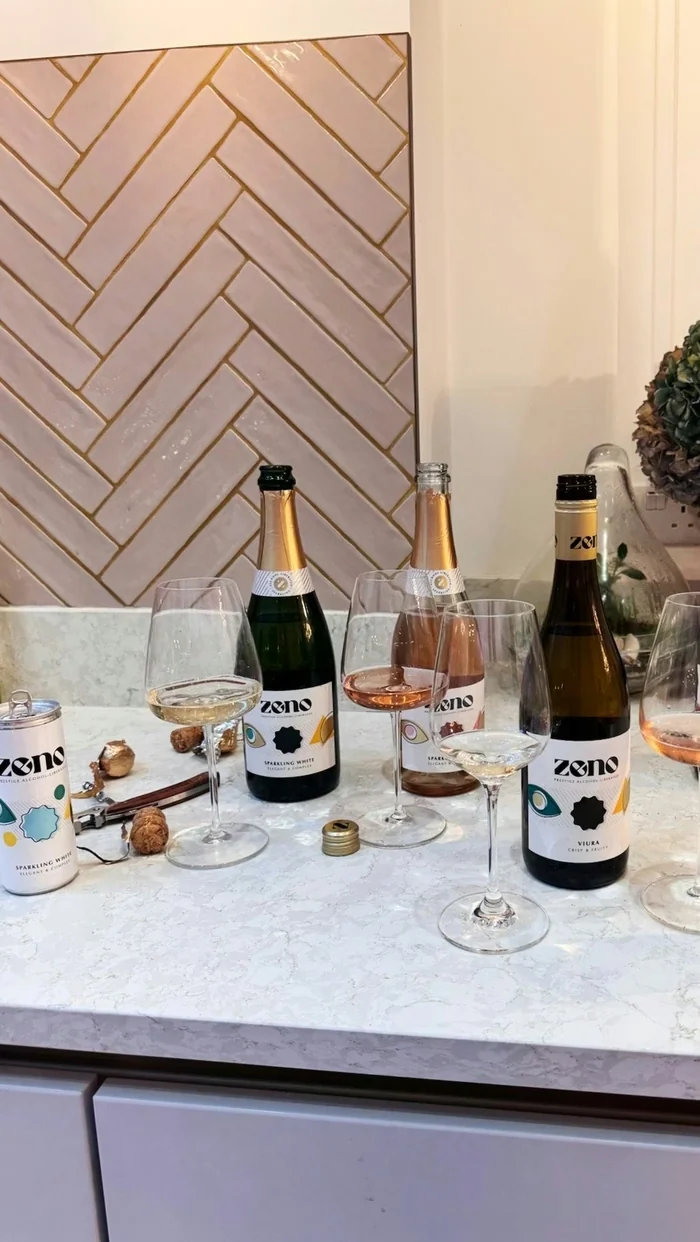 Zeno sparkling wine bottles and glasses arranged on a marble kitchen counter