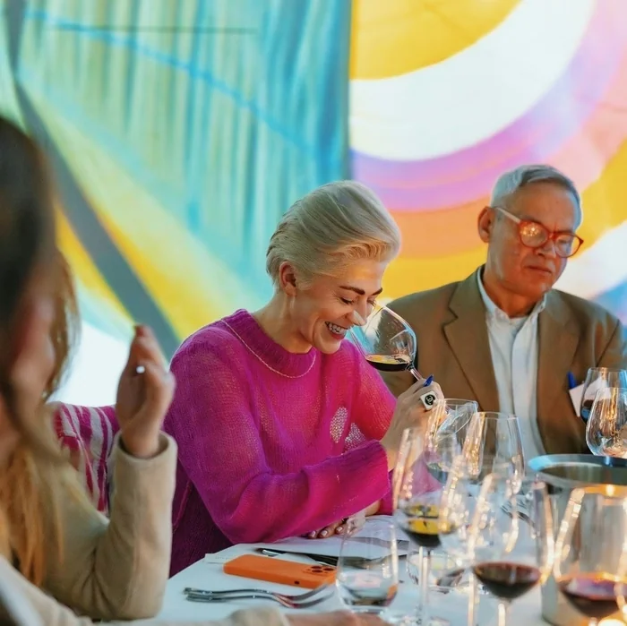 Guests savour red wine at a colourful tasting table