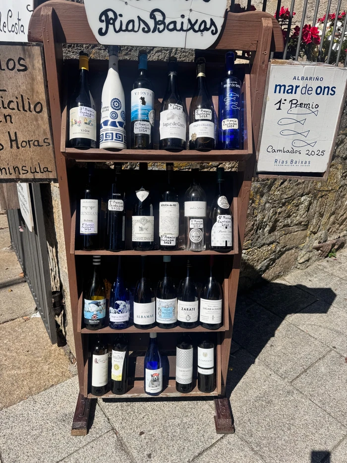 Display of Albariño wine bottles beside a Rías Baixas sign outdoors