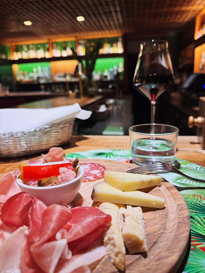 Wine glass and platter of Italian cheeses and cured meats on a restaurant table