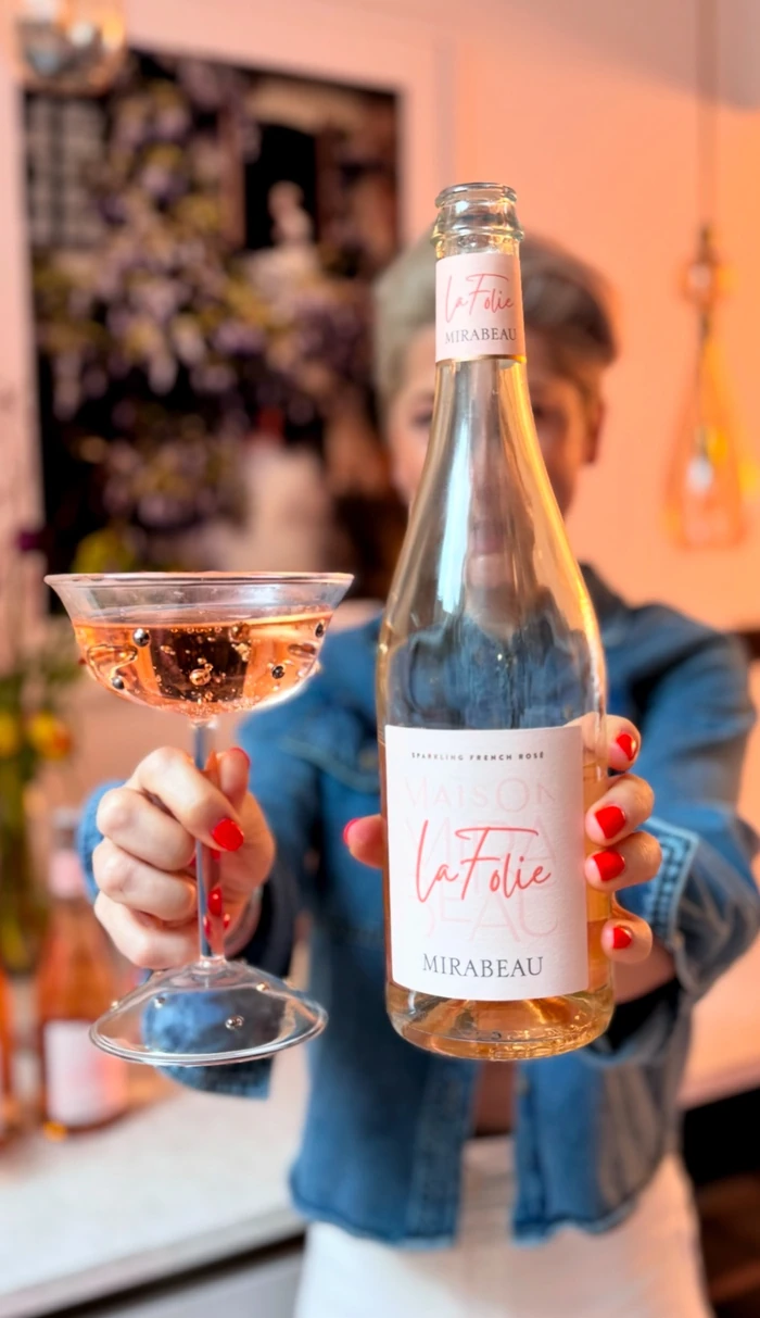 Bottle of Maison Mirabeau La Folie rosé held beside a glass of sparkling rosé