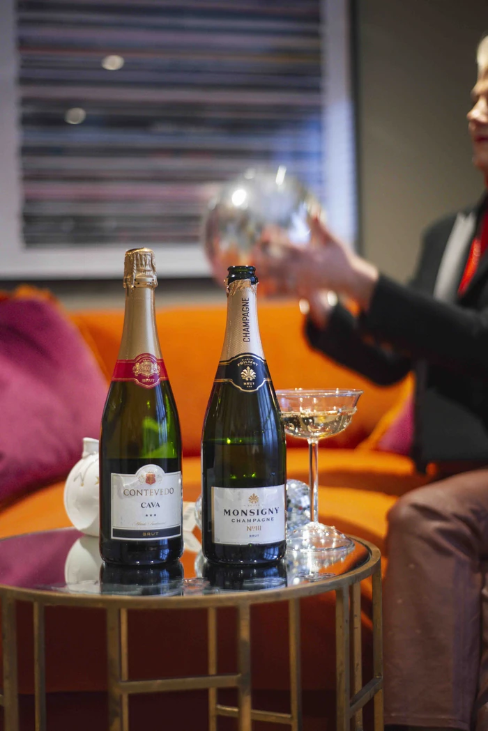 Two bottles of sparkling wine and glasses on a drinks trolley at a tasting event