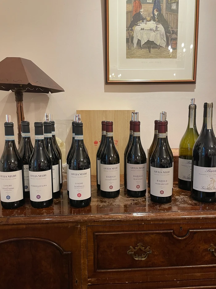 Giulia Negri Barolo and Langhe wine bottles displayed on a wooden sideboard