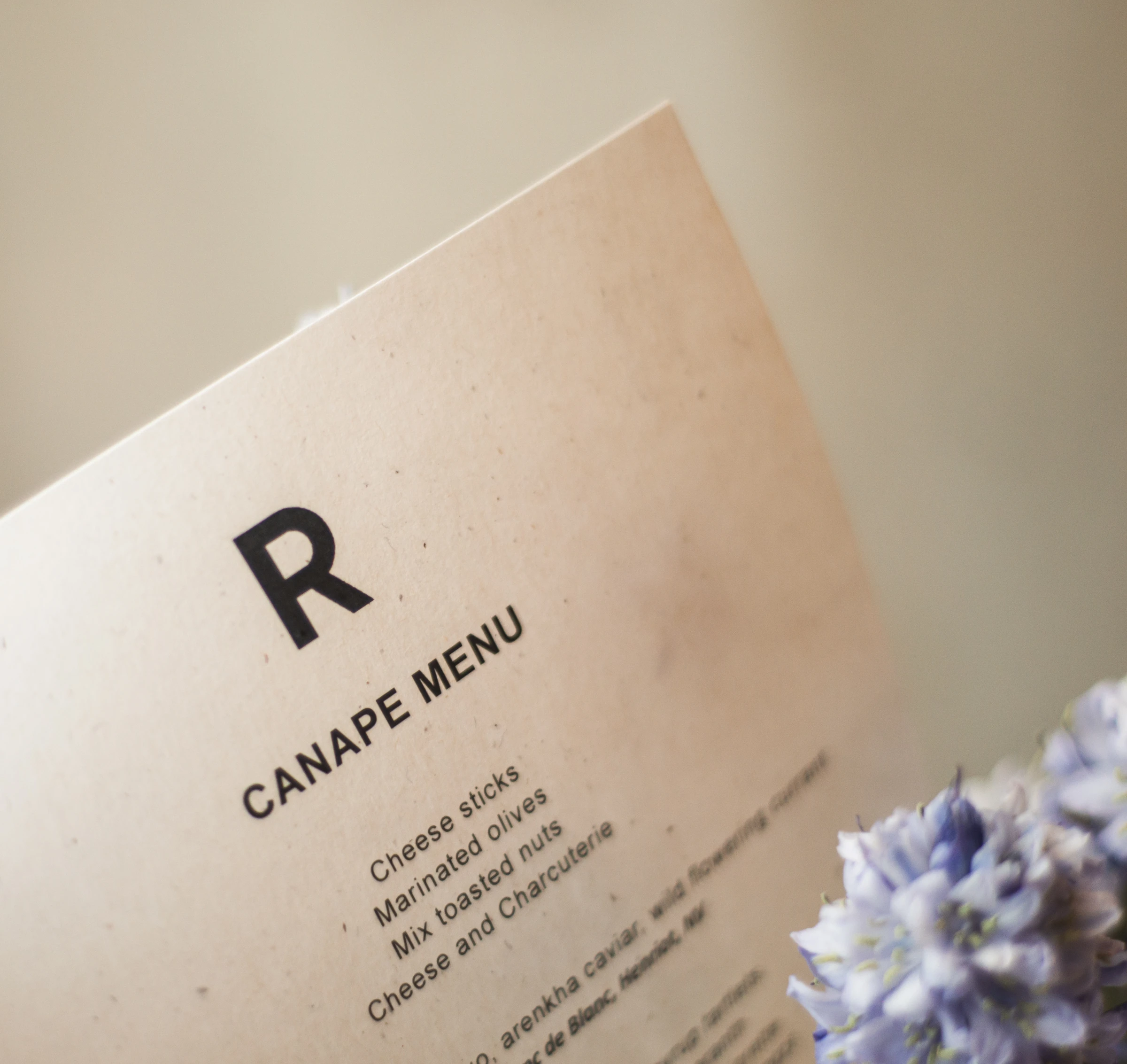 Canape menu beside a cluster of pale blue flowers