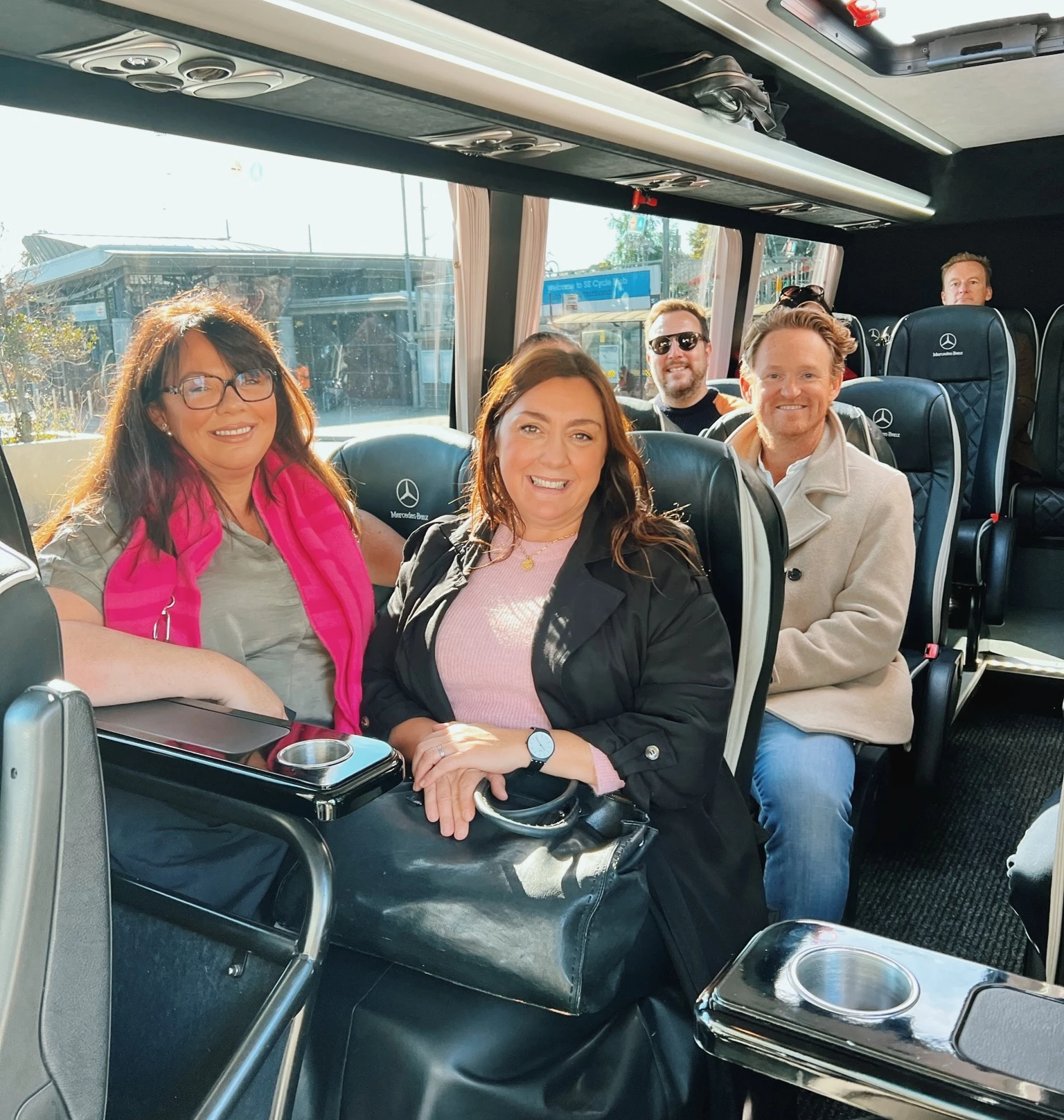 A group of people travelling in a Mercedes minibus during an English vineyard visit