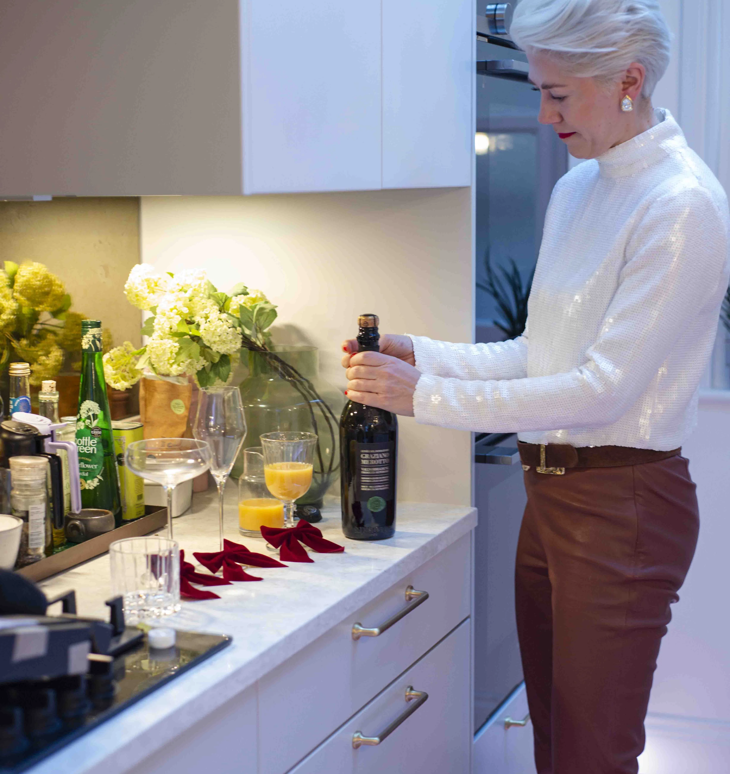 Woman preparing a festive prosecco cocktail in a kitchen