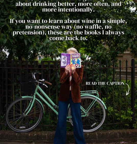 Person holding wine books in front of a bicycle, with text about learning about wine and drinking more intentionally.