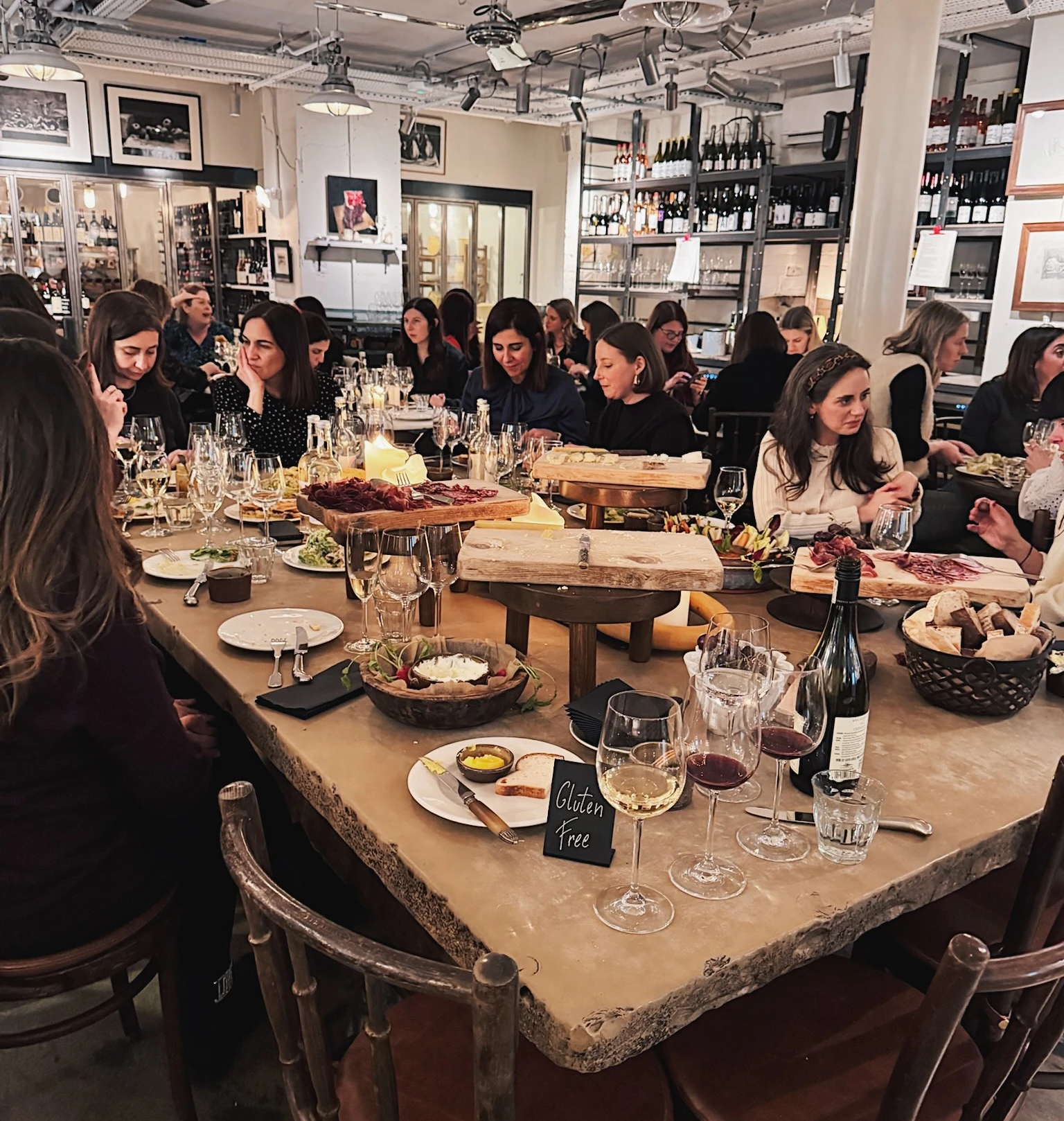 Guests enjoy a wine tasting with glasses, bottles, sharing boards and a gluten-free place card