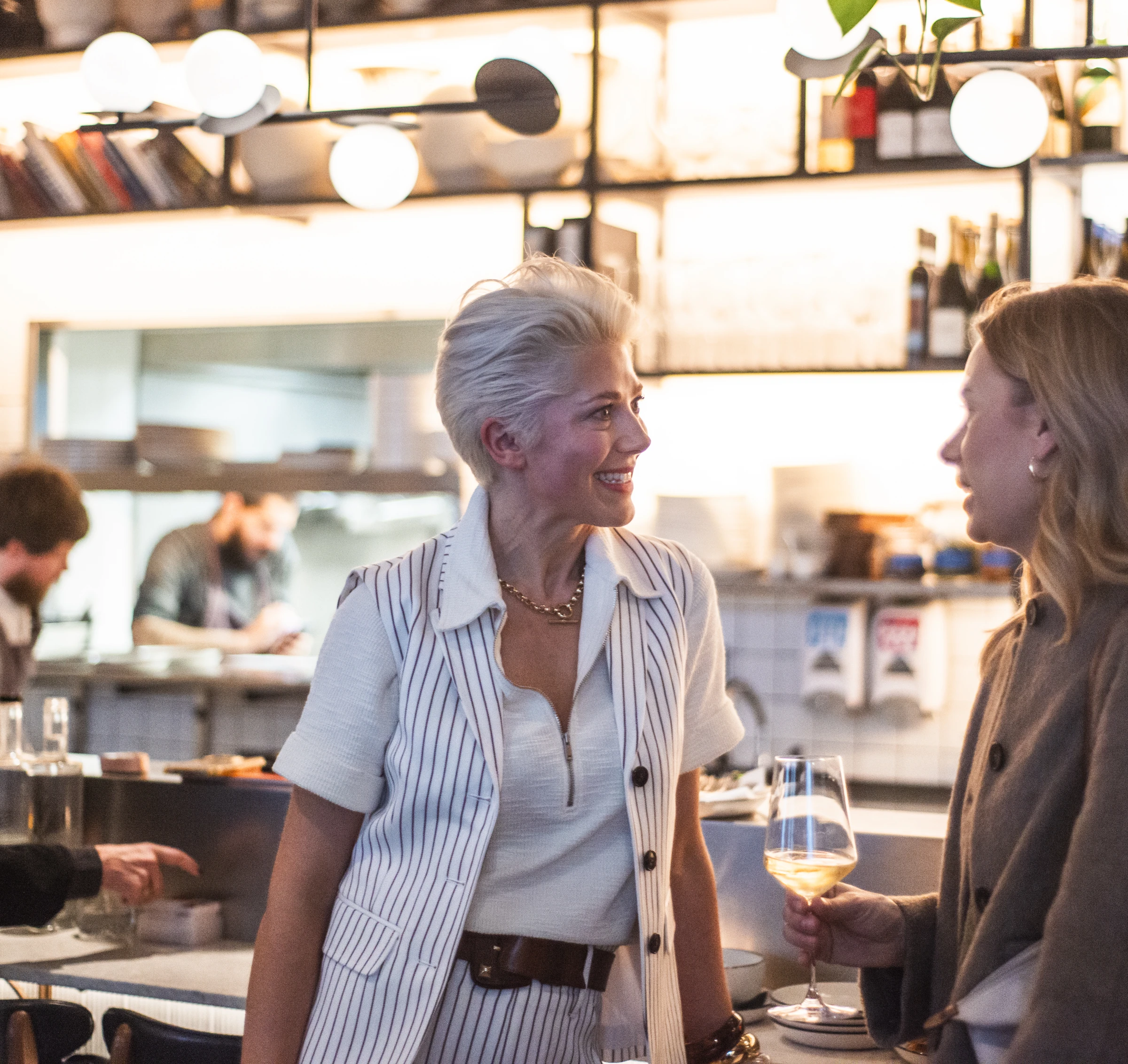 Guests chat over wine at a stylish restaurant bar