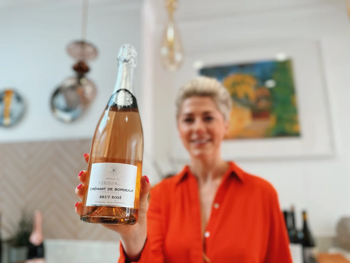 Woman holding bottle of Crémant de Bordeaux sparkling rosé wine