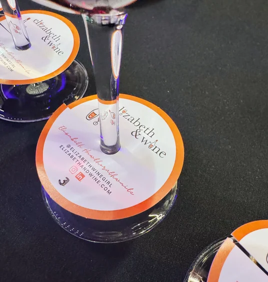 Wine glasses with Elizabeth & Wine tasting cards on a dark table