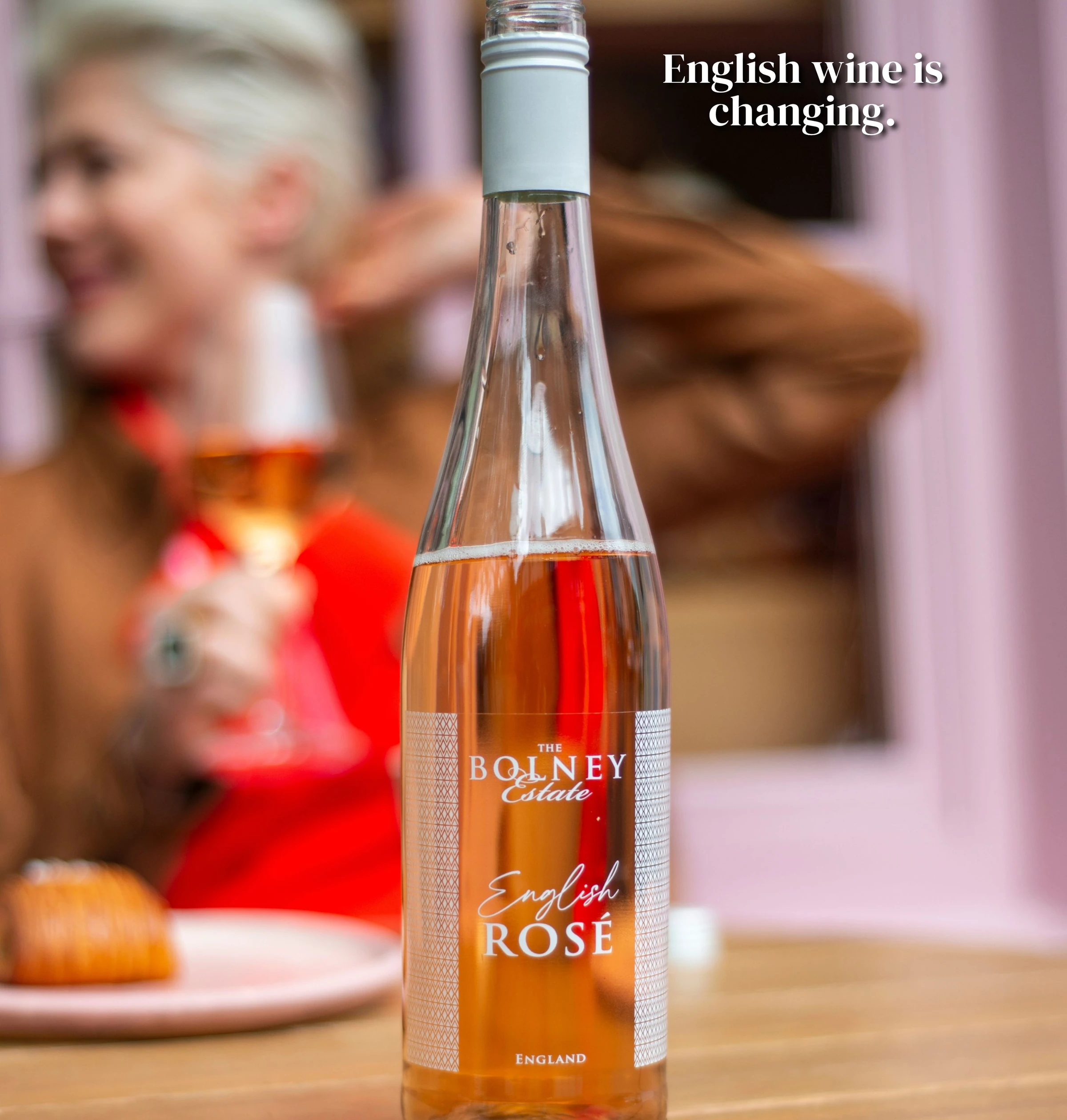 Bottle of Bolney Estate English Rosé wine in front of a blurred tasting scene