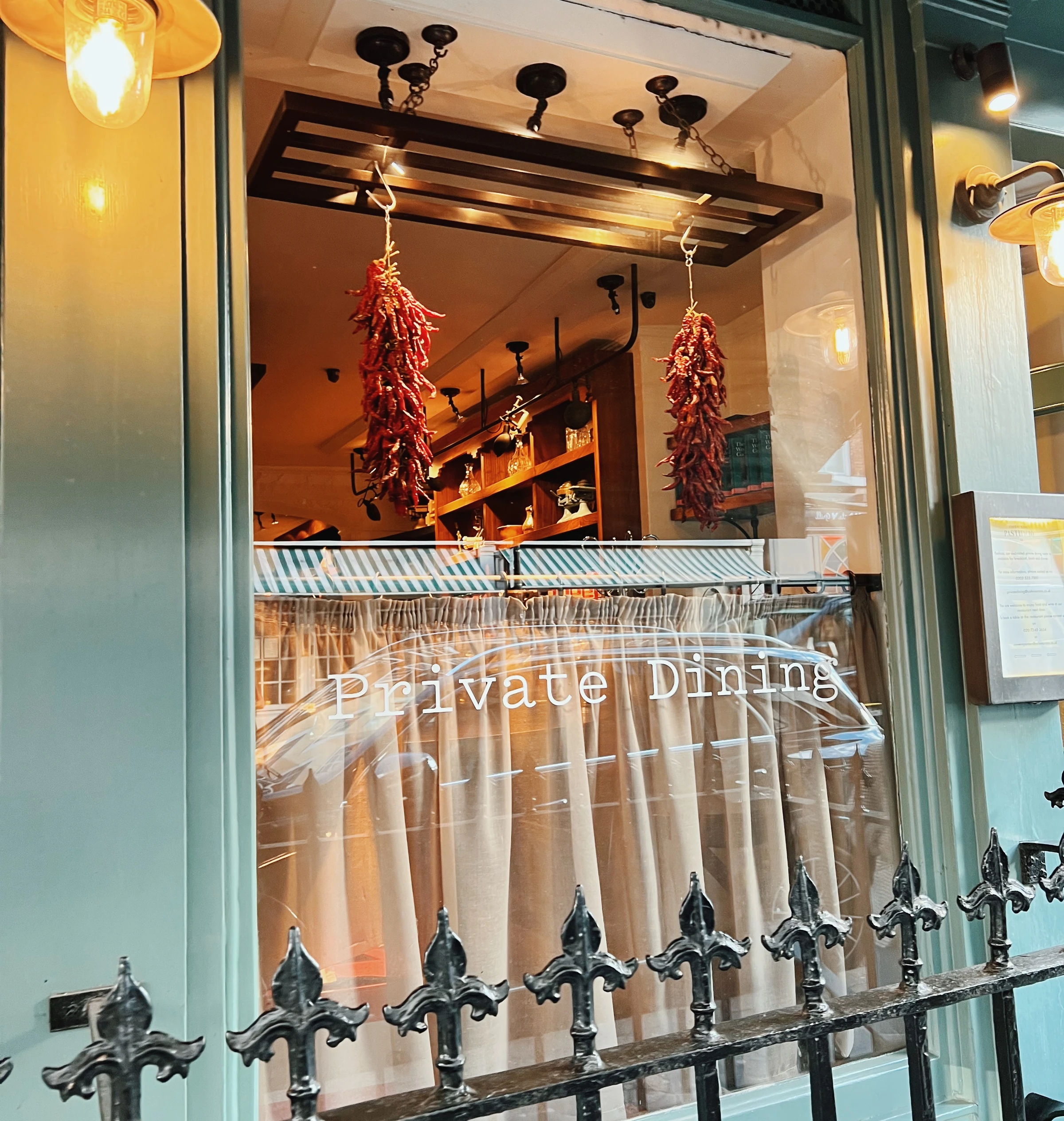Restaurant frontage with hanging dried chillies, warm lighting and a Private Dining sign