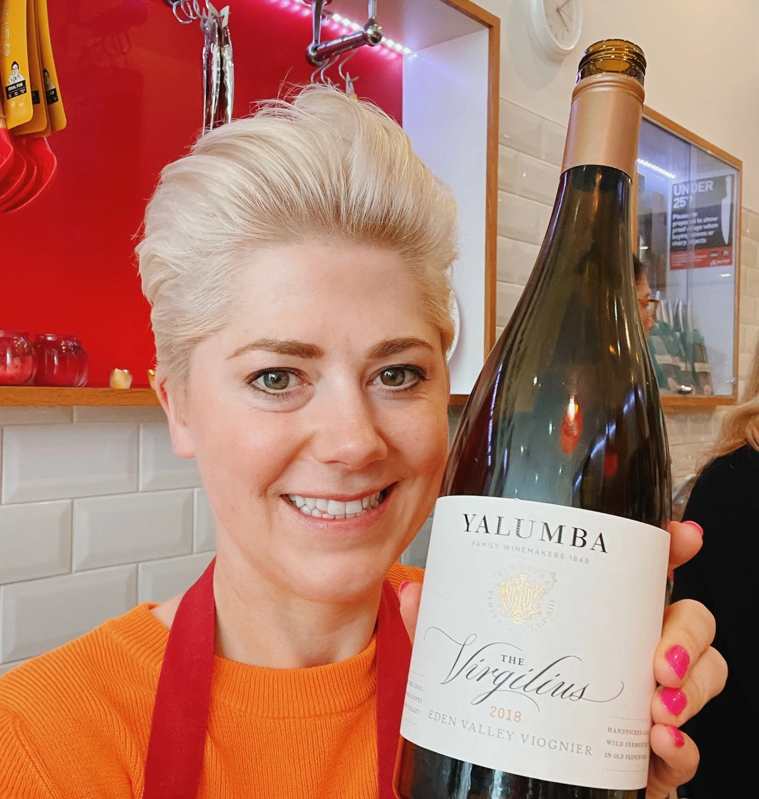 Smiling person holding a bottle of Yalumba The Virgilius Viognier
