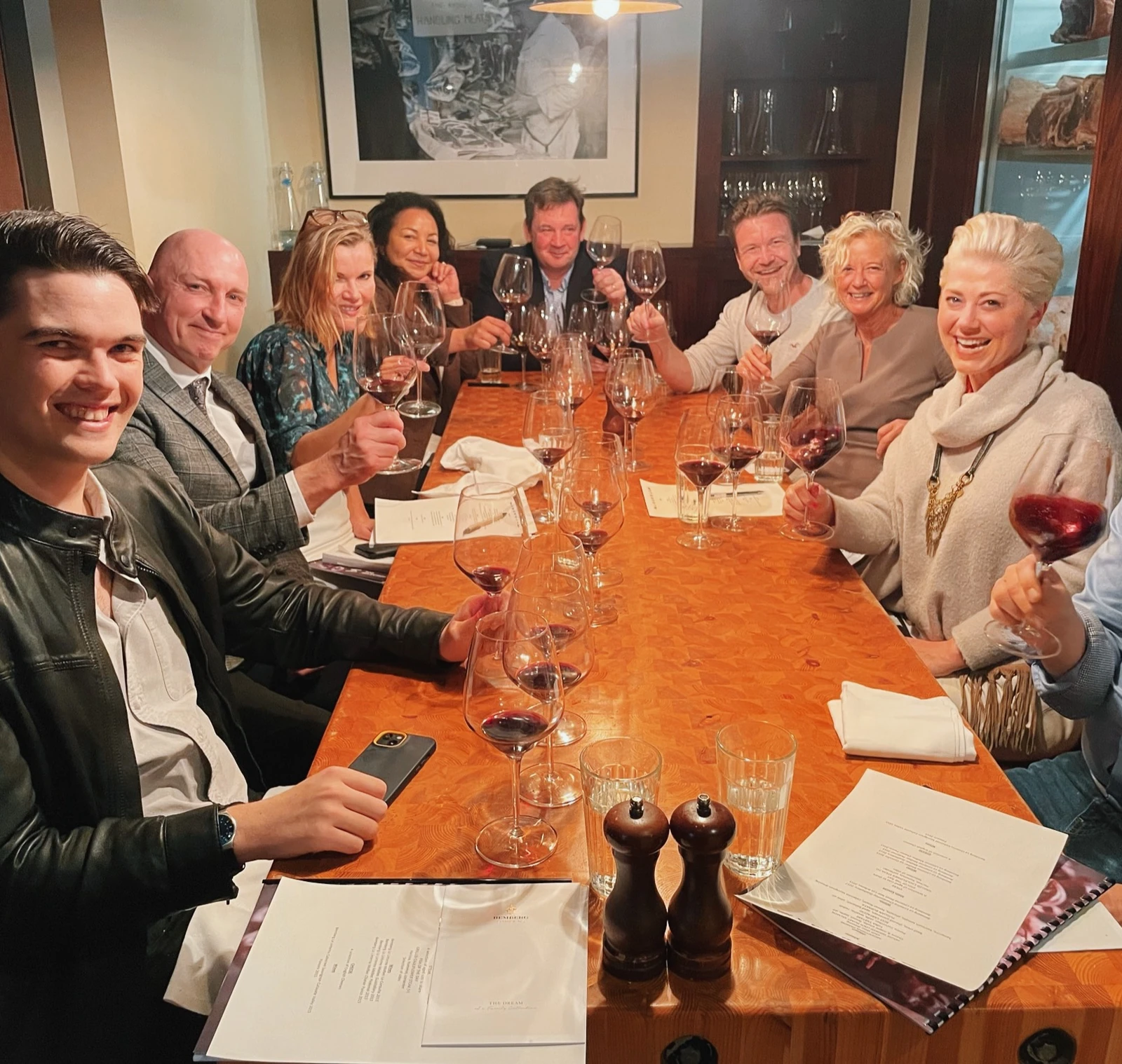 Group raising wine glasses around a restaurant table during a tasting