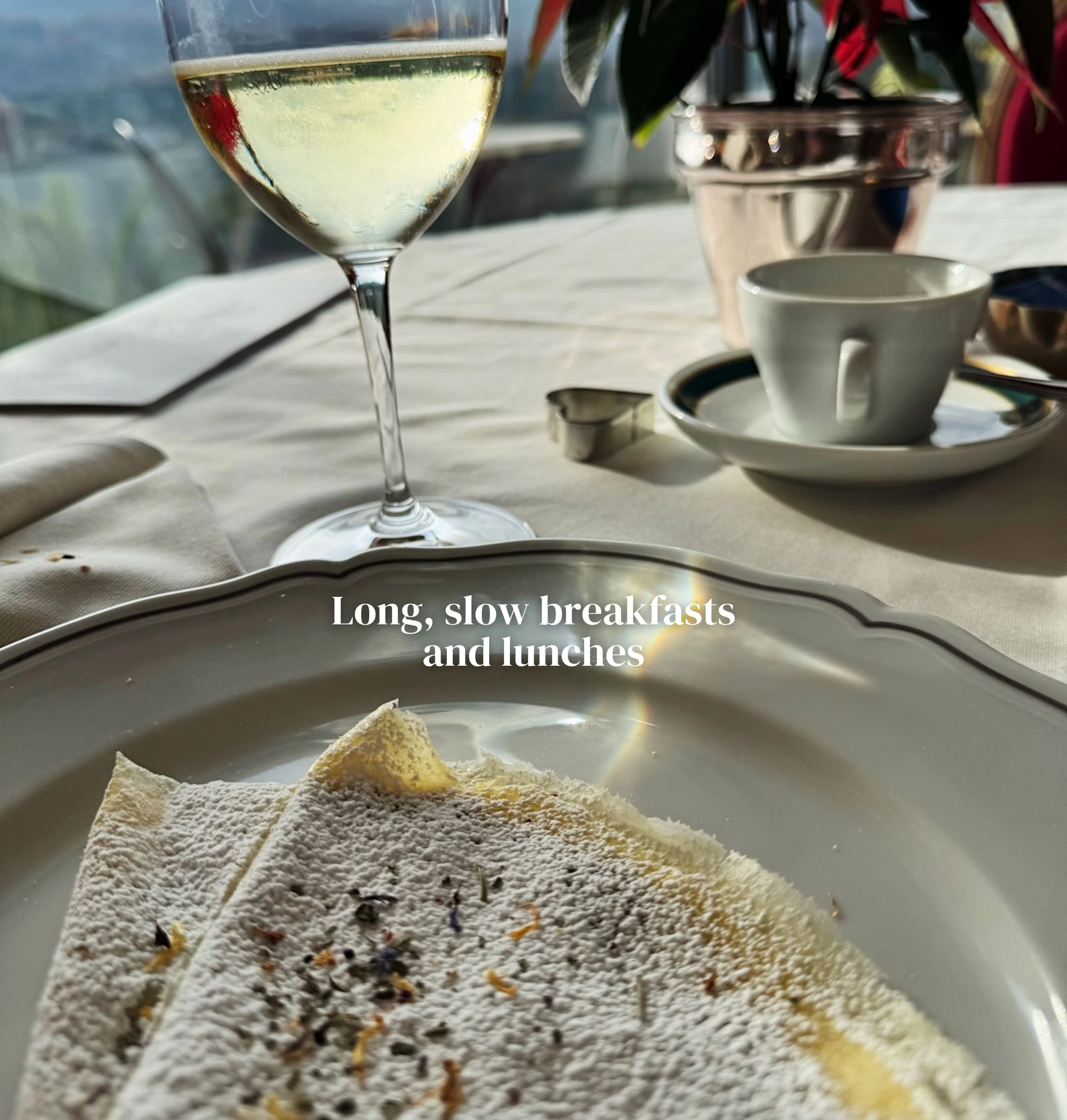 White wine, coffee and breakfast at a table overlooking mountains
