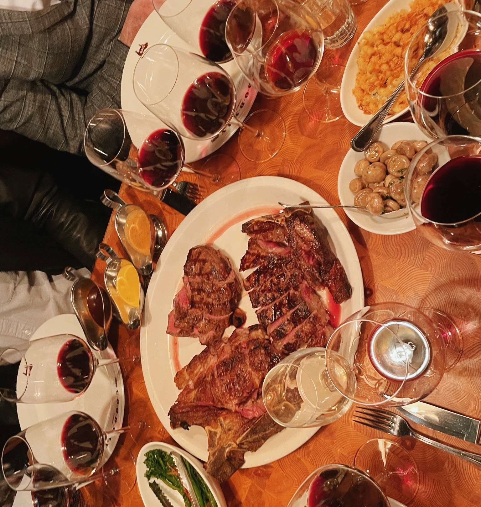 Overhead table setting with red wine, steak and side dishes