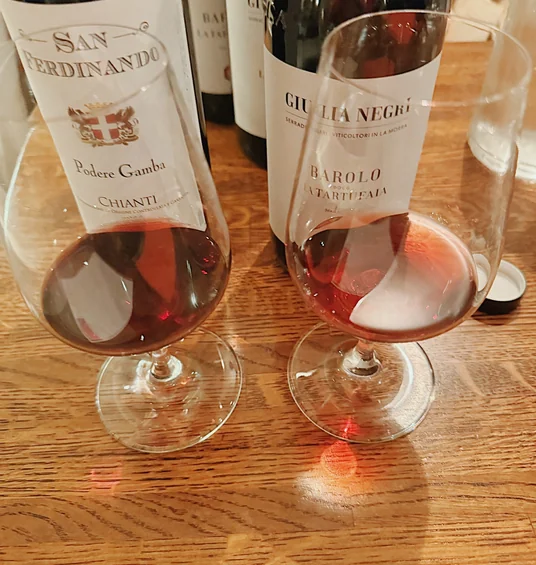 Italian wine bottles and partially filled wine glasses on a wooden table