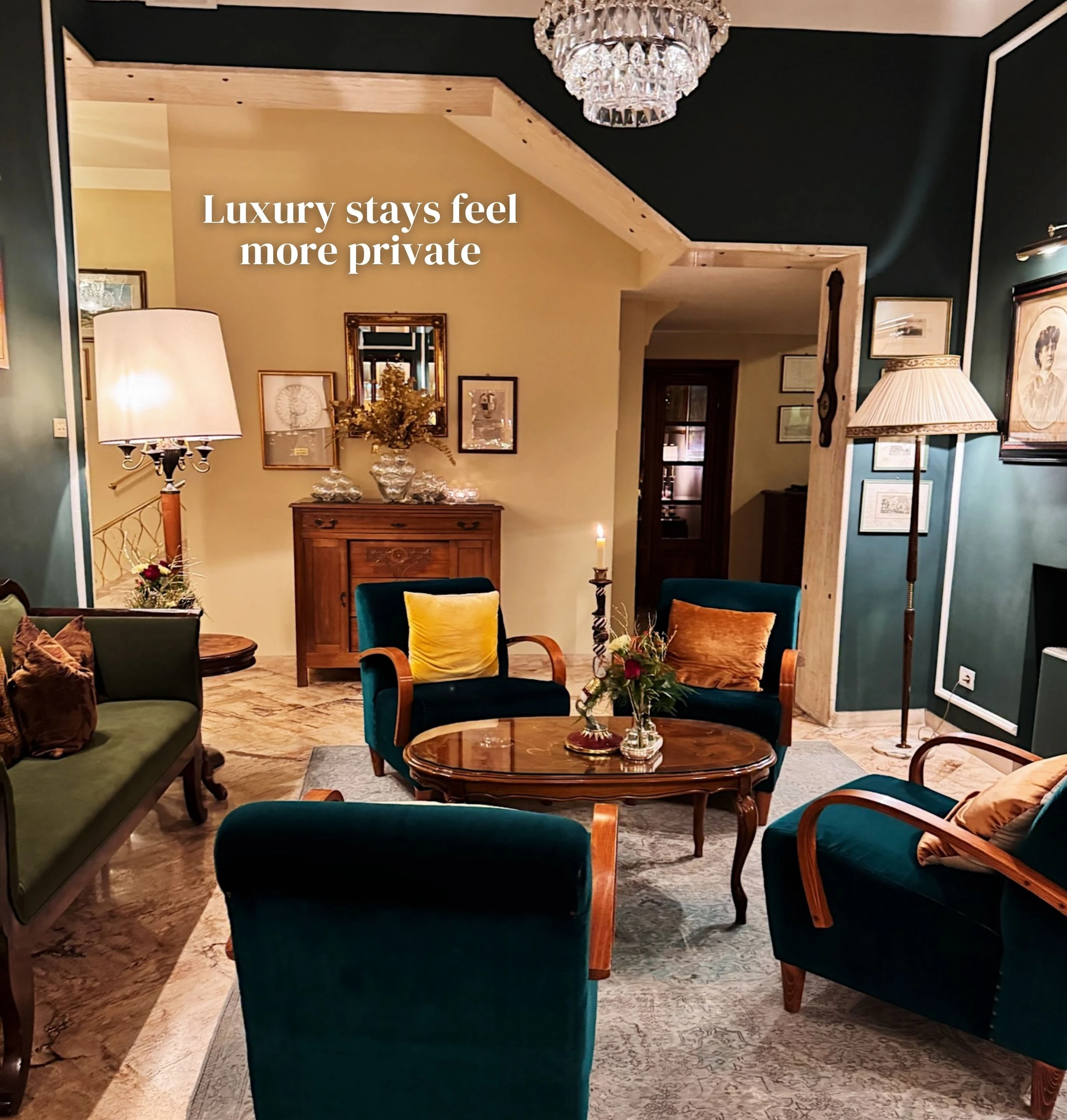 Elegant private sitting room with velvet chairs, artwork, lamps and a crystal chandelier