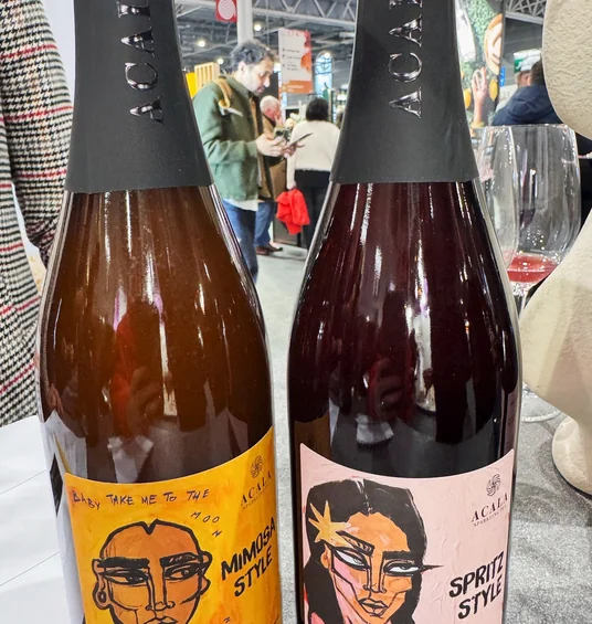 Two sparkling wine bottles with illustrated labels, one marked Mimosa Style and the other Spritz Style