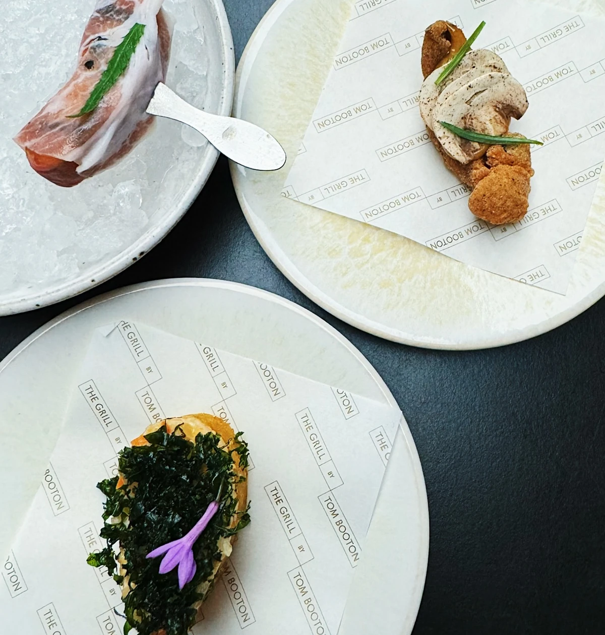 Plated dishes from The Grill by Tom Booton on branded paper