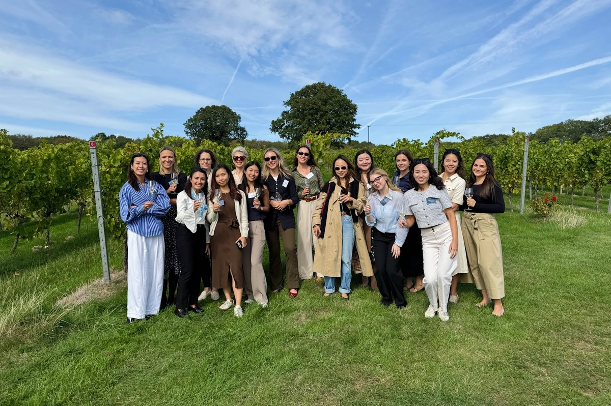 Group of women posing in a vineyard under a blue sky