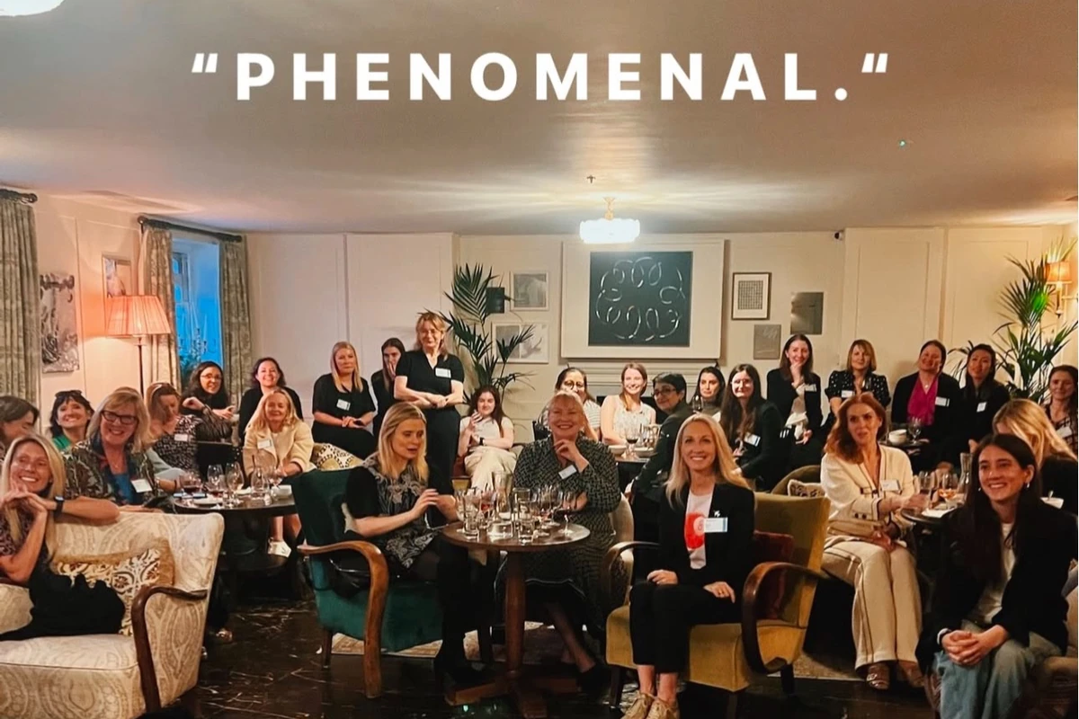 Group of women seated and standing in a stylish room beneath the word PHENOMENAL