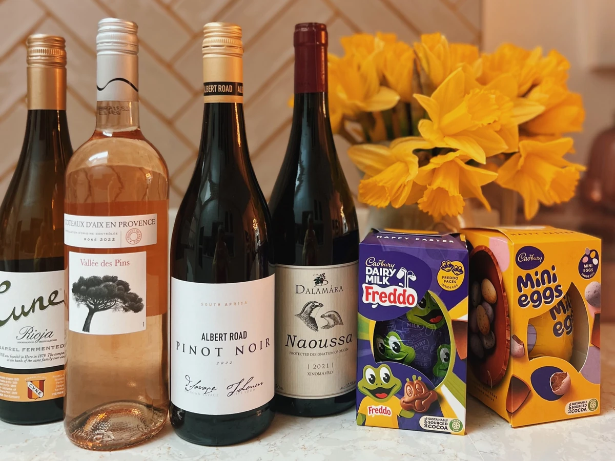 Four wine bottles, yellow flowers and Cadbury Freddo and Mini Eggs Easter boxes