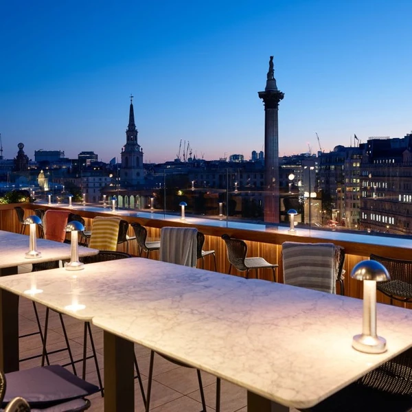 Rooftop restaurant terrace overlooking London landmarks at dusk