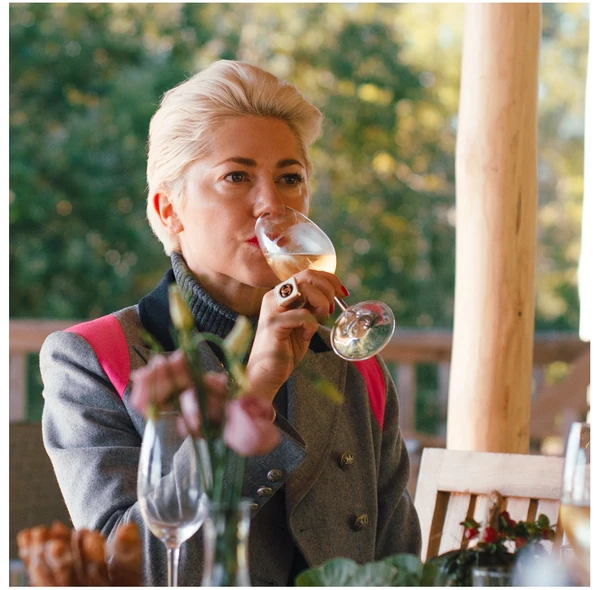 Woman smelling white wine from a glass outdoors
