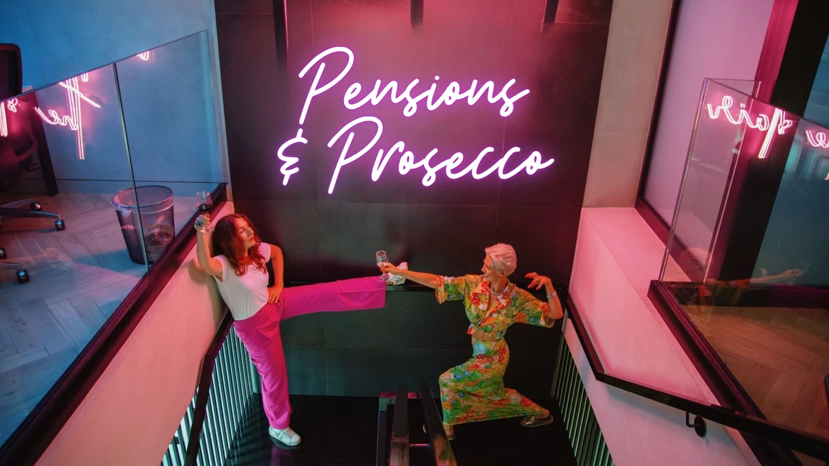 Two people holding glasses beneath neon Pensions & Prosecco sign