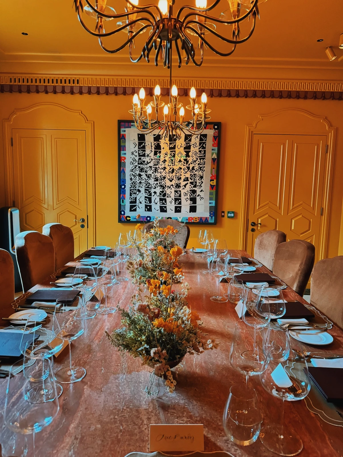 Elegant dining room with chandelier, decorated table, floral centrepiece and colourful artwork