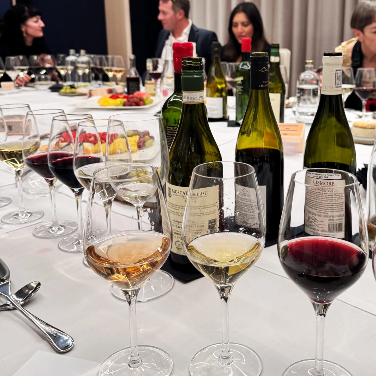 Wine bottles and glasses on a dining table during a tasting event